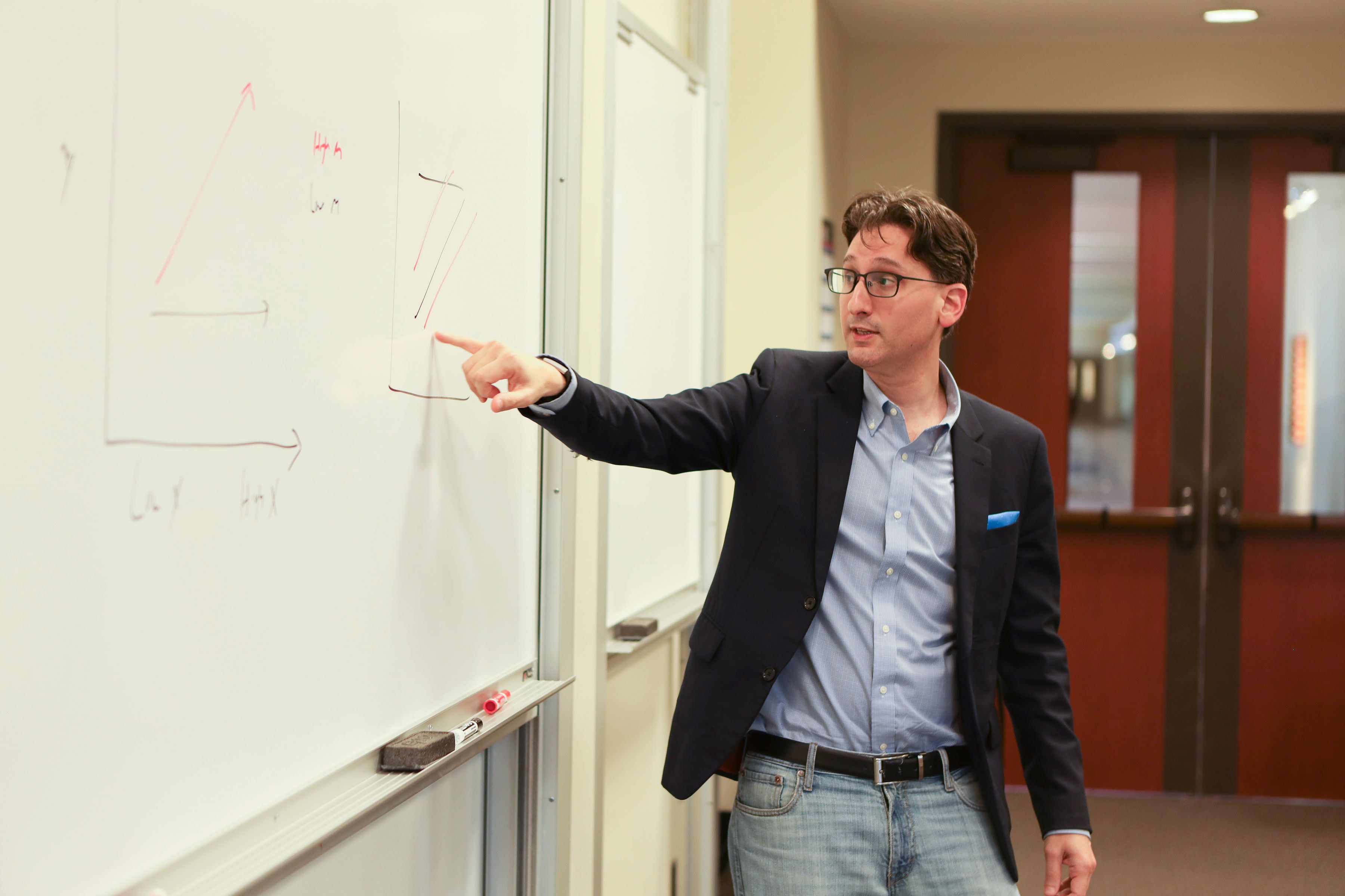 Elad Sherf at a whiteboard, teaching.